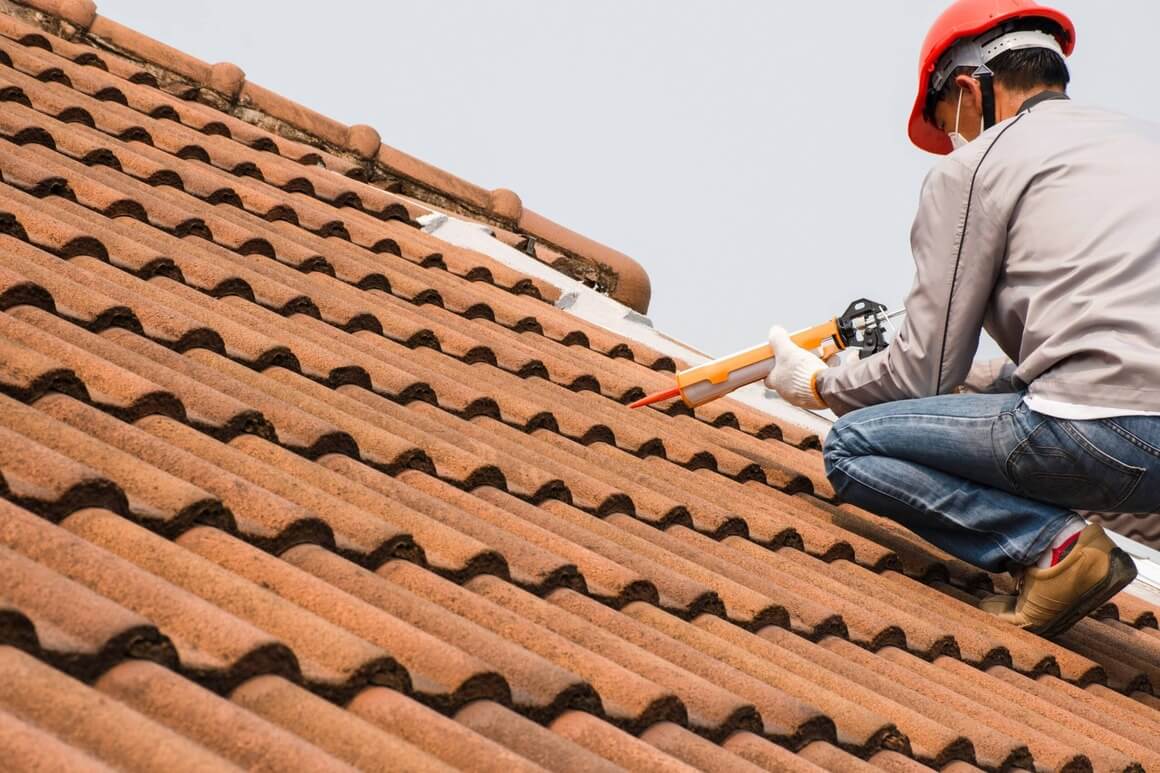 man installing tiles on roof