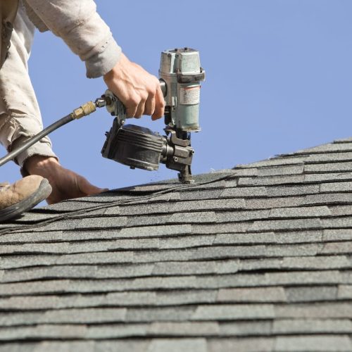 man repairing the roof with tool